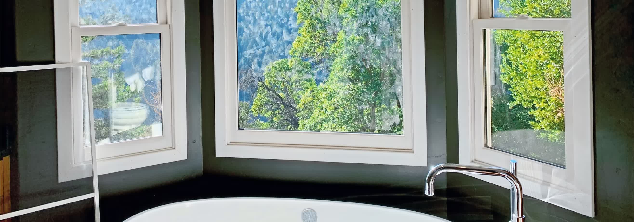 Corner soaking tub with bay windows in a remodeled bathroom