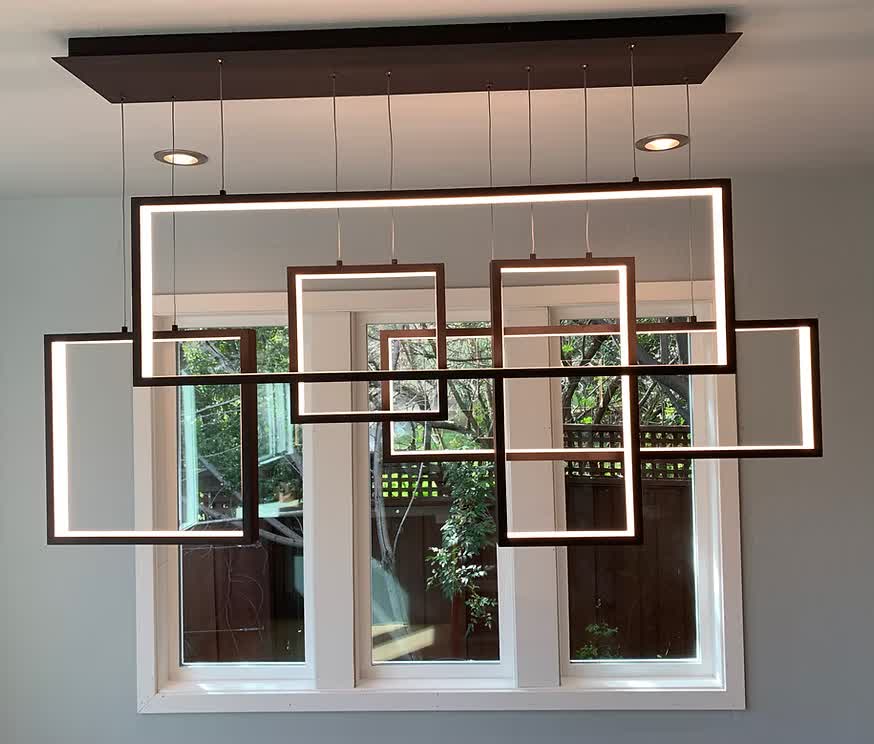 Modern geometric pendant lighting fixture installed over a dining area
